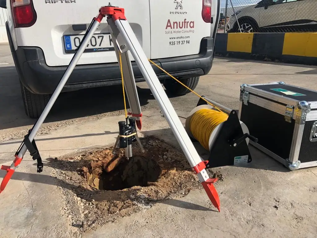 Equipo técnico instalando una sonda de nivel para monitoreo de aguas subterráneas en un pozo piezométrico.